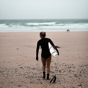 Person Carries Surfboard On The Beach Photo