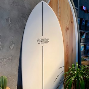 white surfboard leaning on white wall