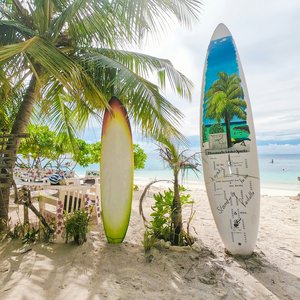 white and blue surfboard on beach during daytime