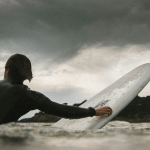 man swimming with surfboard